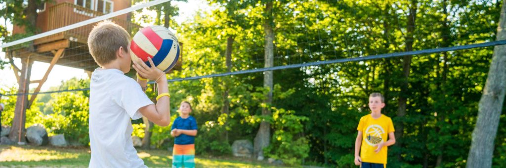 Male camper spiking a volleyball